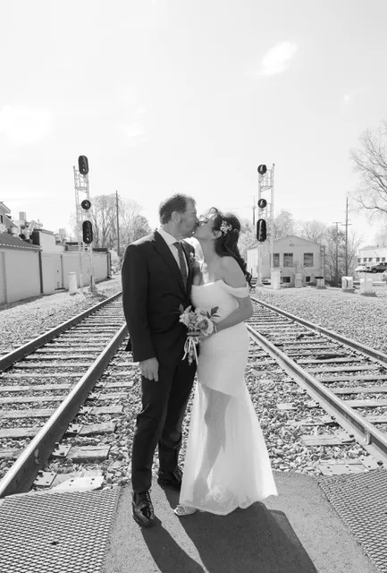A wedding portrait on the tracks near the venue