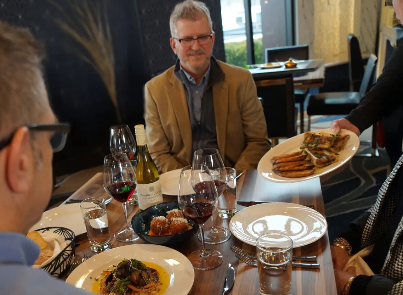 A server setting a plate down at a table in the dining room