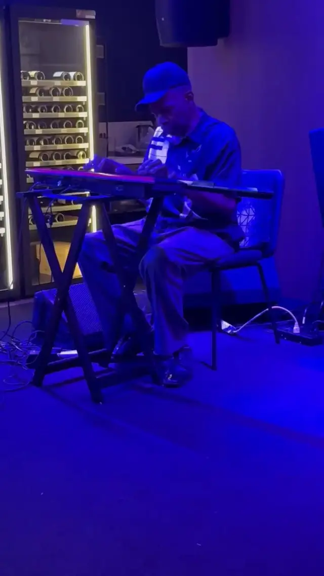 A guitarist playing lap steel under blue light at Chicane