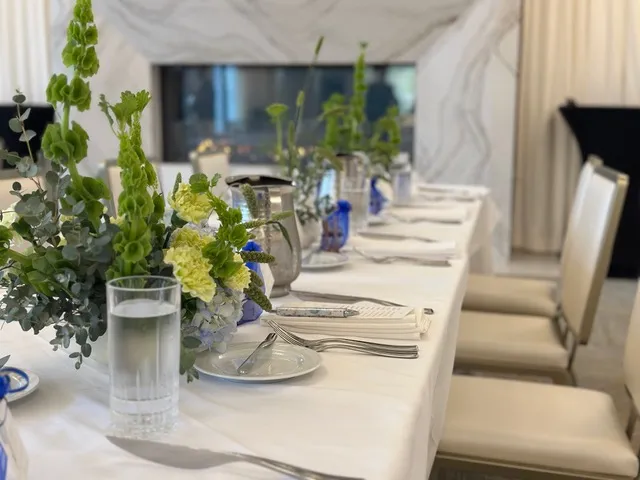 A head table in white and green beside the marble fireplace