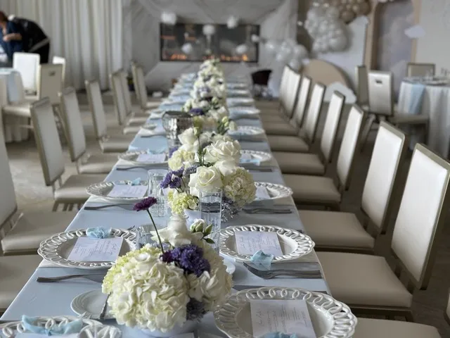 A long table set with white florals and place cards