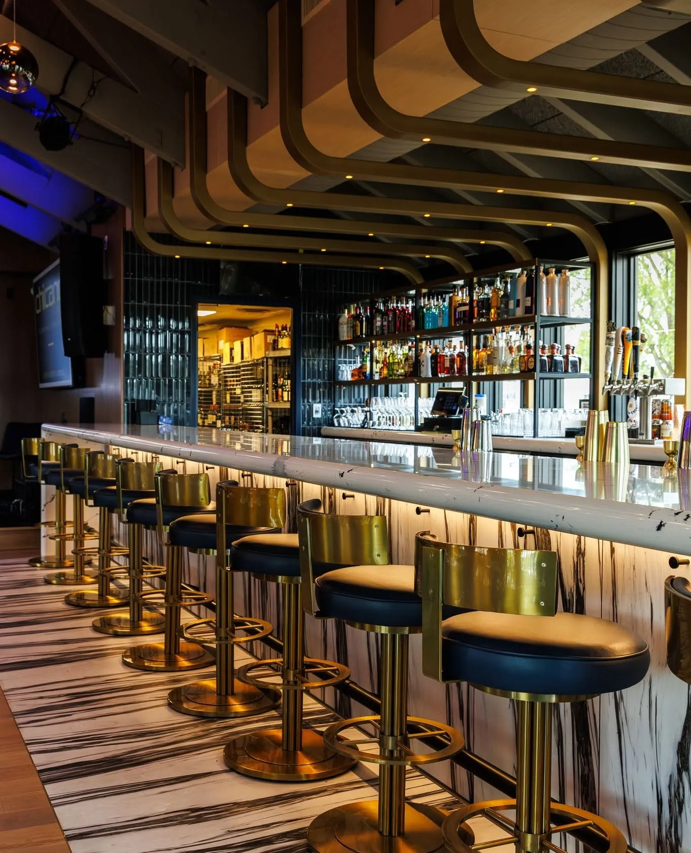 Brass stools along the marble bar
