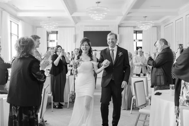 A newly married couple walking out through applauding guests
